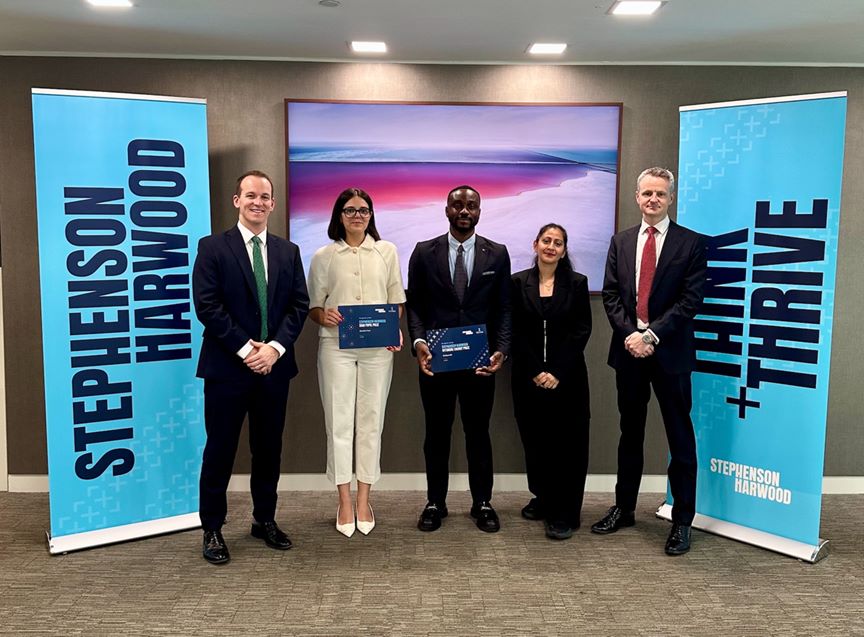 five people standing in front of Stephenson Harwood sign