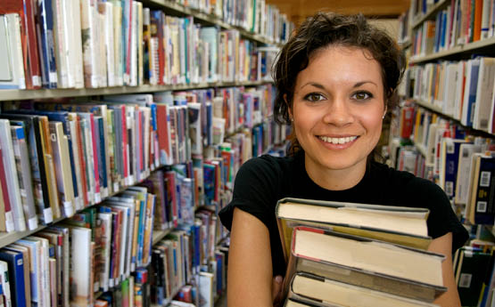 female in library holding books