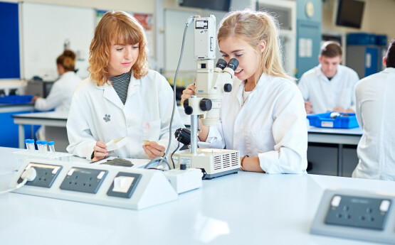 Geography students looking into microscope