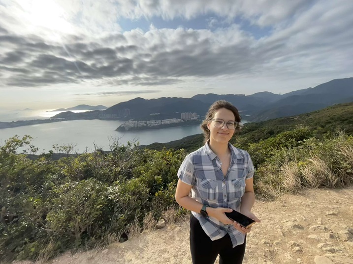 Student standing in front of coastline