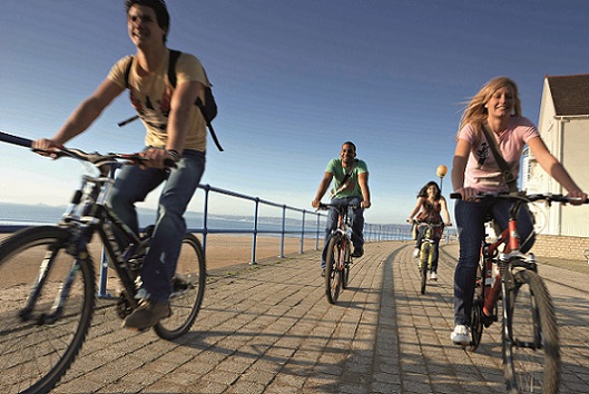 Students riding their bikes along the seafront