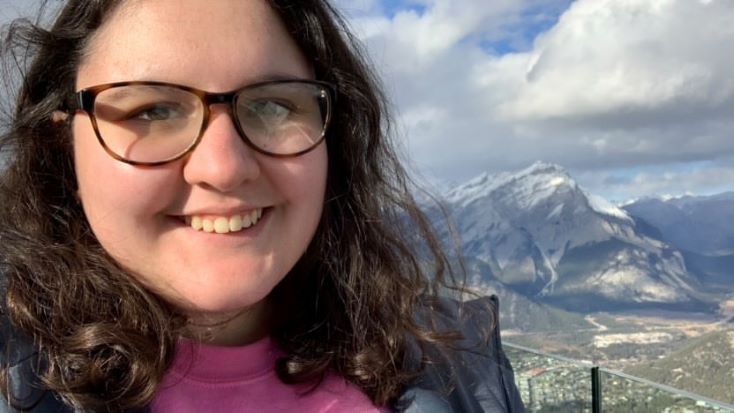 student in front of ice mountain