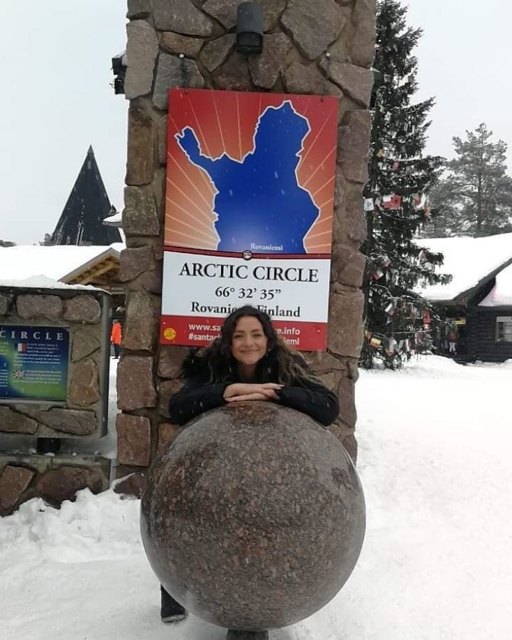 student in front of arctic circle sign