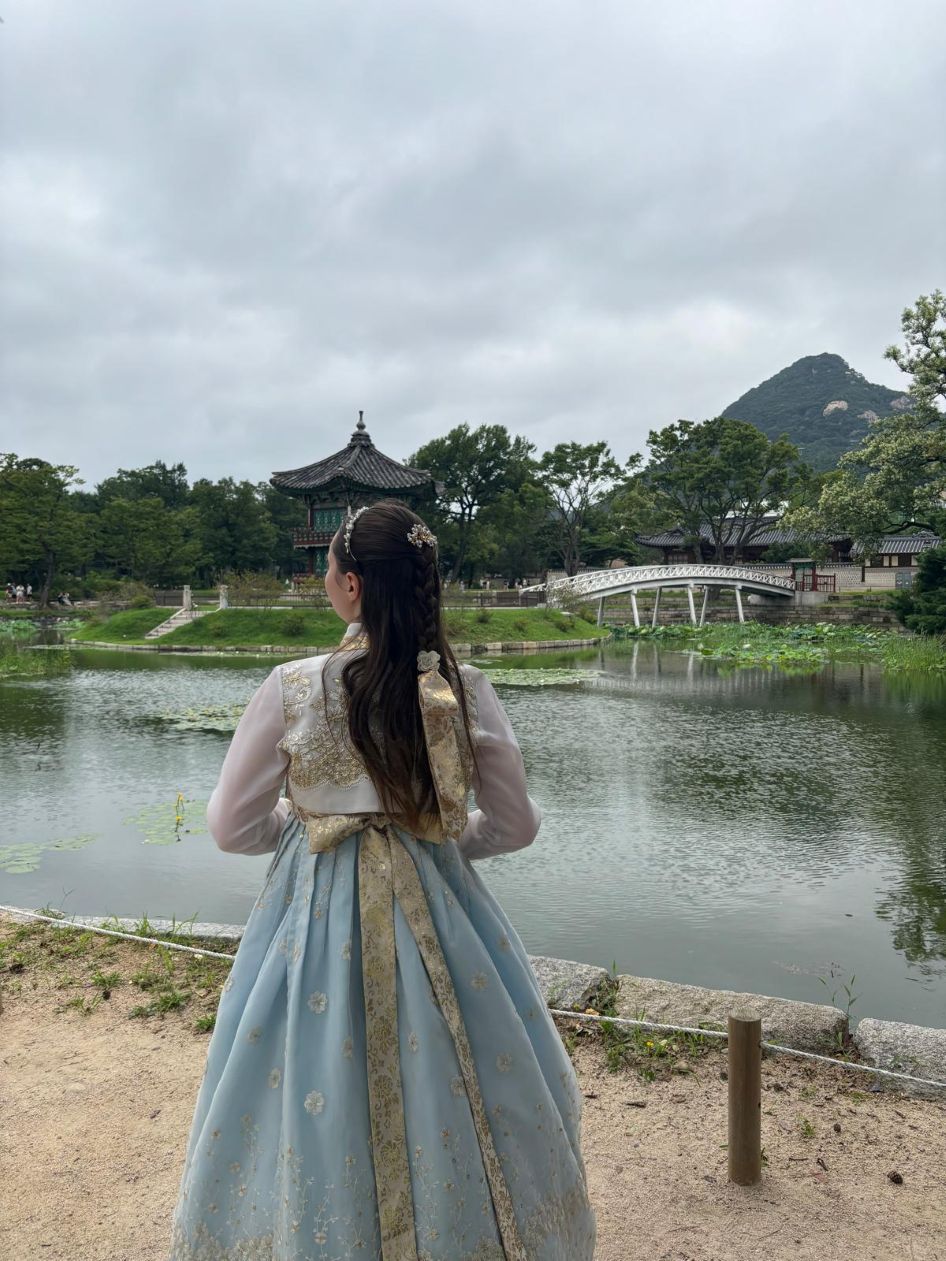 Student in Korean traditional dress in front of lake in Busan. 