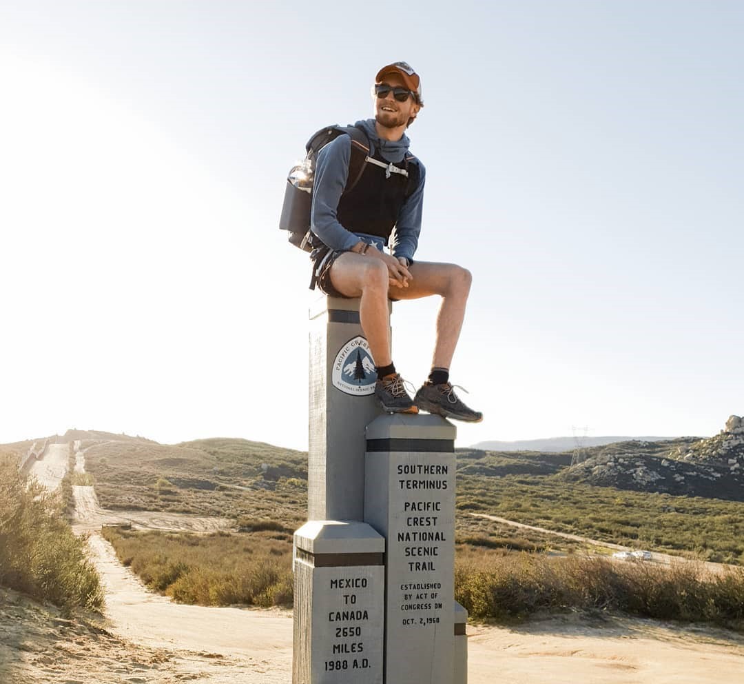 Student sat on top of a pillar