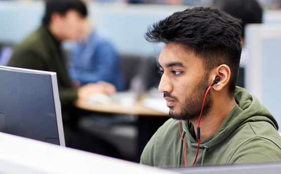 A student working at a computer in the library