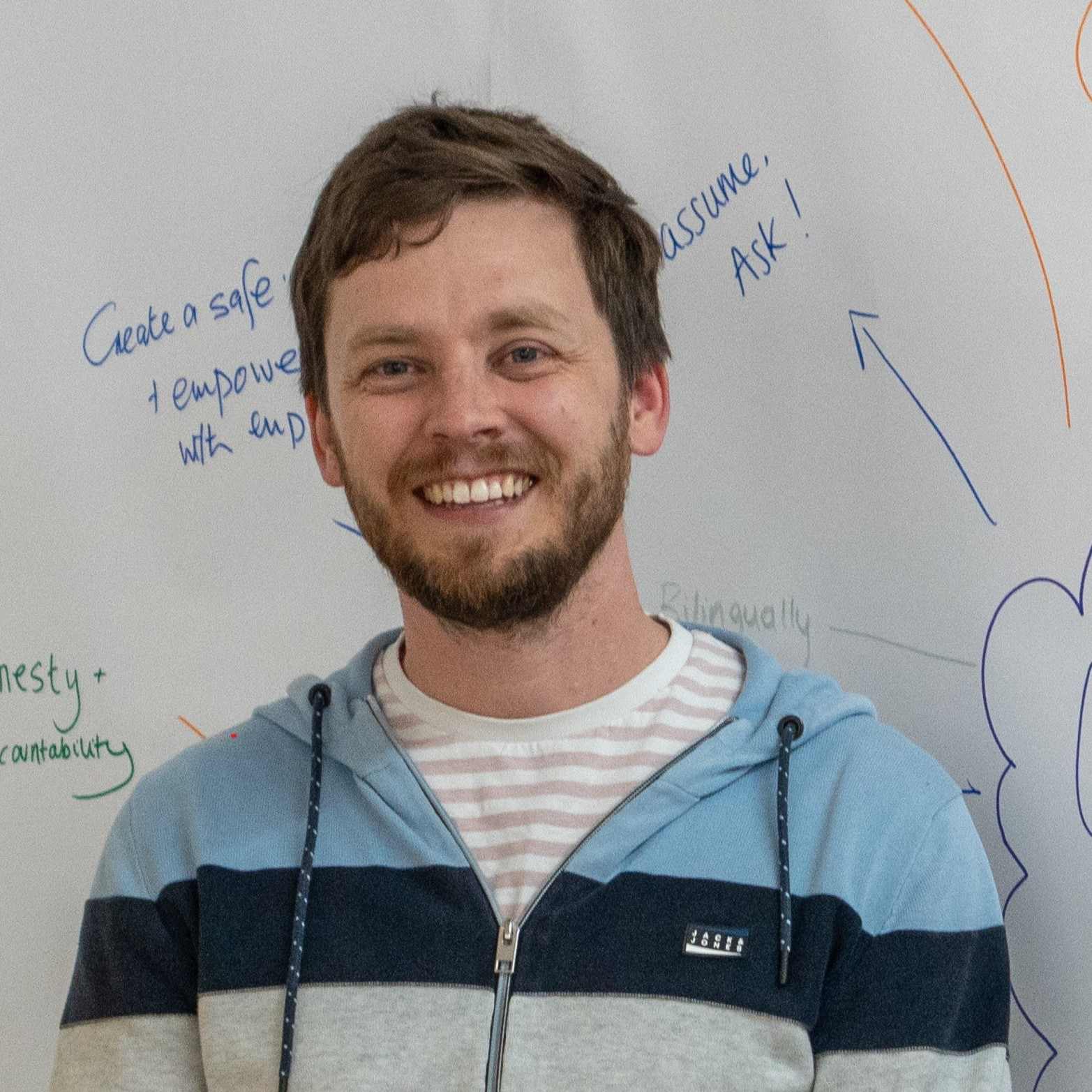 Headshot of Tom in front of whiteboard