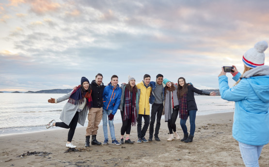Group of students posing for photo on the beach. 