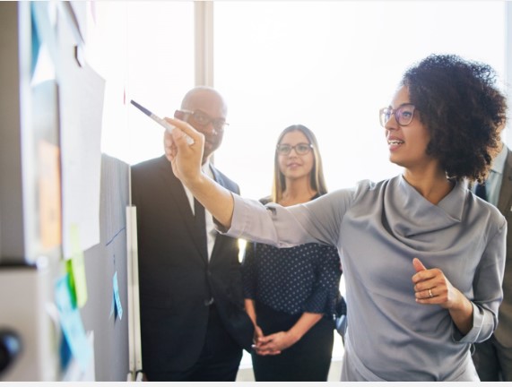 Training session with trainer pointing at a board of post-its