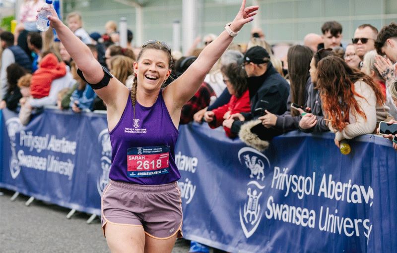 An image of a runner finishing the Swansea Half Marathon.