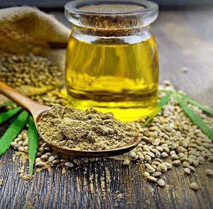 glass jar of cannabidiol and hemp powder on a wooden spoon