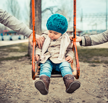 Child on swing with parents on swing