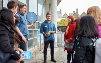 An image of a student delivering a presentation to visitors.