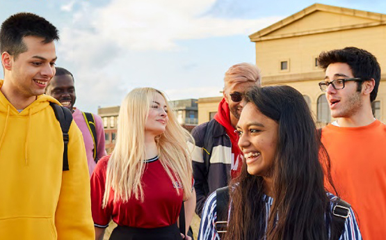 Students walking towards the beach with the Great Hall behind them