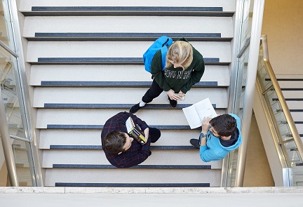 Three students standing on the stairs