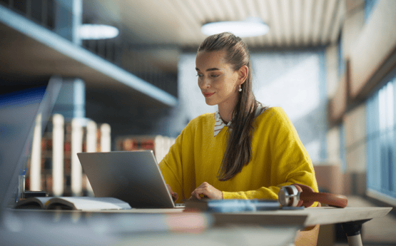 Student on a laptop in a library. 