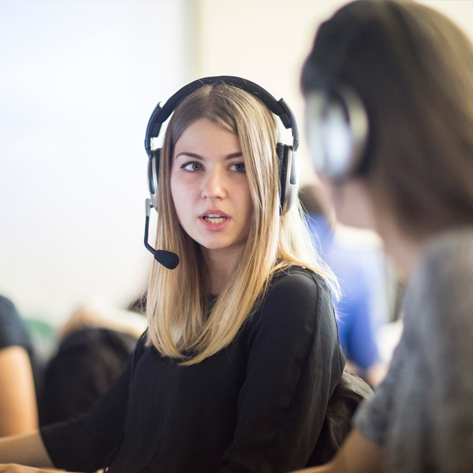 a translation student using a headset on a computer