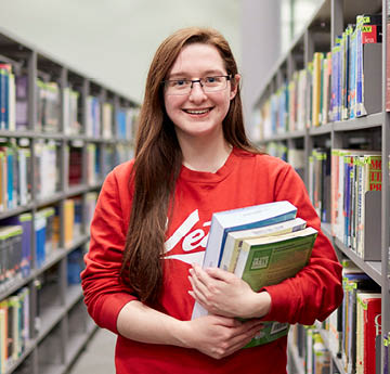 student holding library books