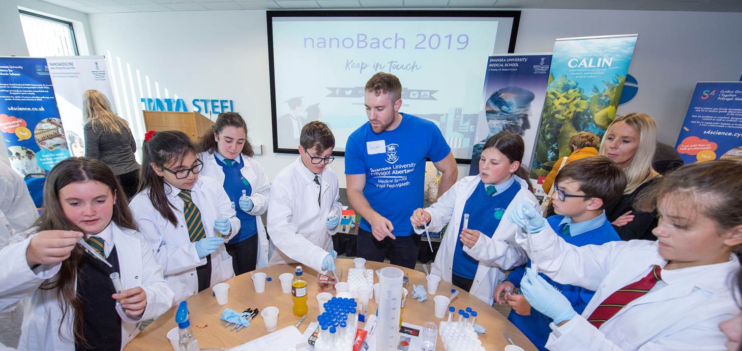 Swansea University Medical School student helping to explain nanotechnology to pupils from across Neath Port Talbot at the NanoBach event.