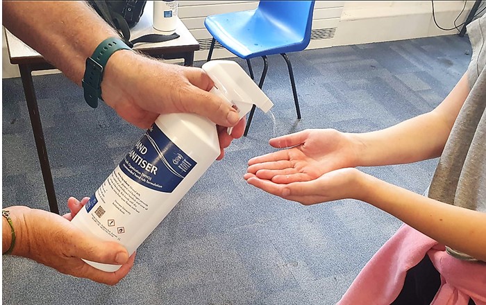 A pupil receiving Swansea Uni hand sanitiser