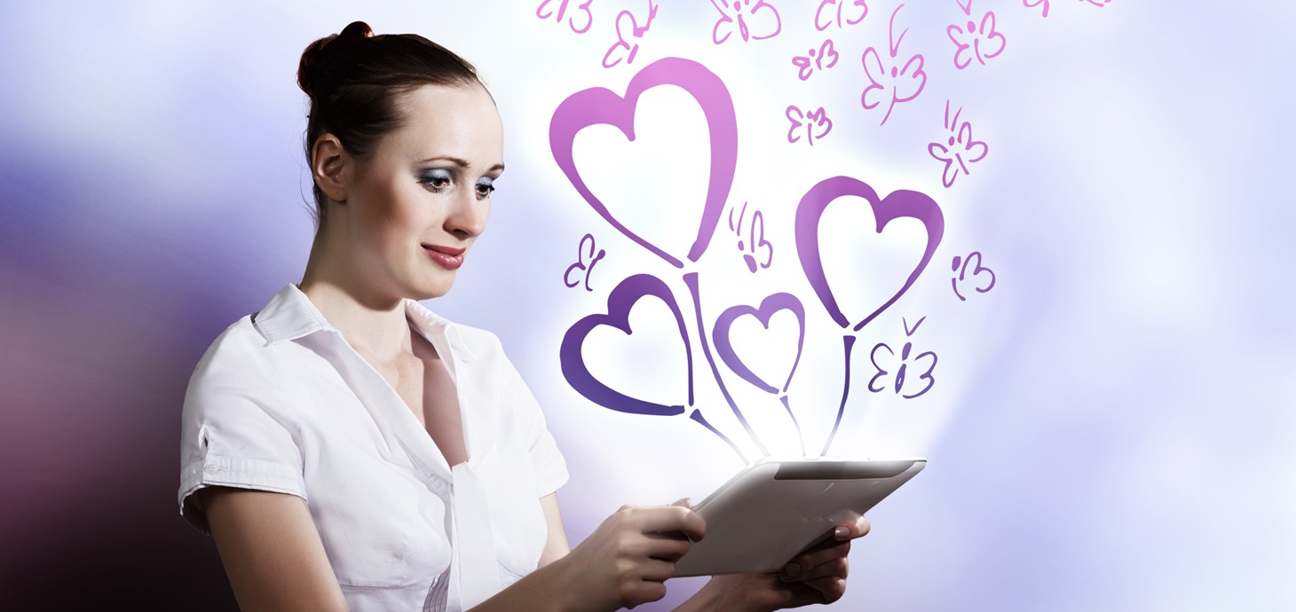 Woman looking at a tablet with graphics of love hearts and butterflies surrounding the screen