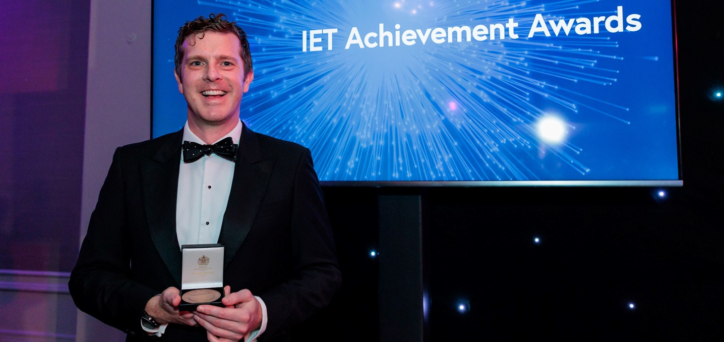 Professor Tom Crick holding his IET Achievement Medal