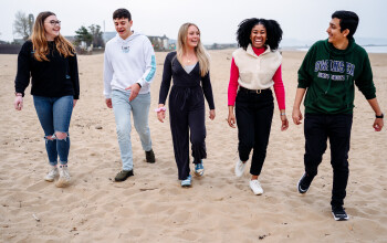 A group of students walking on Swansea beach 