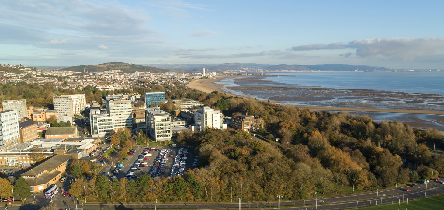 Aerial view of Swansea city and bay with Swansea University in the foreground.