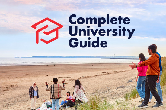 A group of students walking on the beach and the Complete University Guide logo.