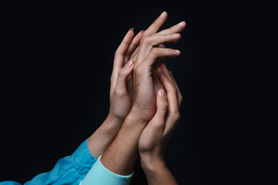 A man's hand with two female hand holding either side