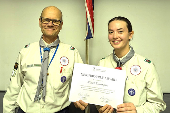 Student Niamh Dorrington receiving her Neighbourly Award certificate from Scout Leader Ben Ball.