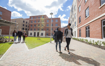 Students walking outside accommodation buildings on the Bay Campus