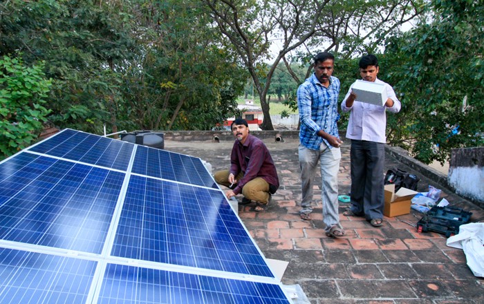 Researchers from Professor Satish Patil’s group at IISc Bangalore standing next to a solar-powered micro-grid they installed at a school in Tamilnadu, India, as part of Swansea University’s SUNRISE project.