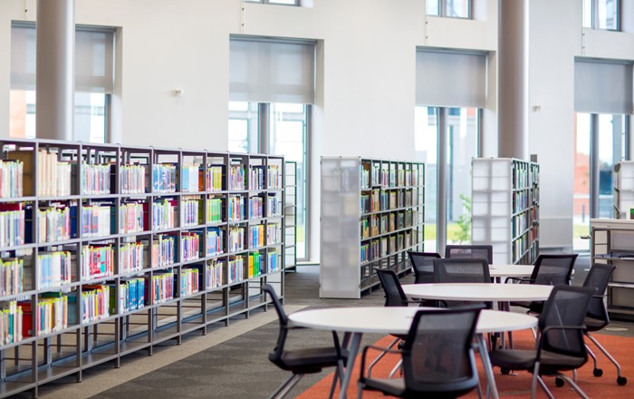 A photo showing the inside of Swansea University’s Bay Campus Library. There are bookshelves and empty tables.