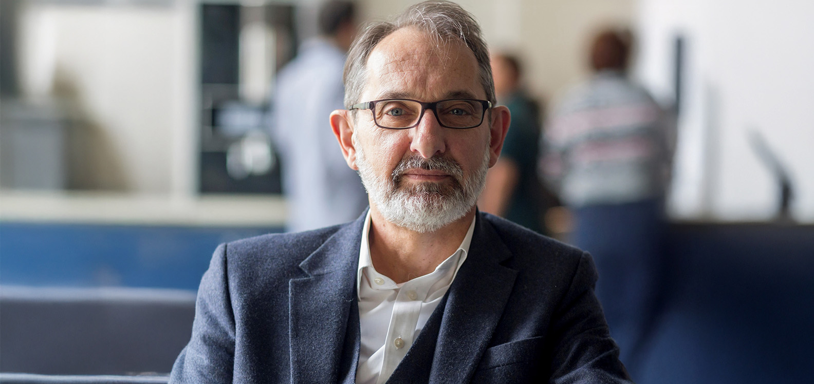 Head and shoulders picture of smartly dressed white man wearing glasses.