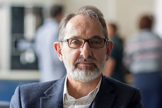 Head and shoulders picture of smartly dressed white man wearing glasses.