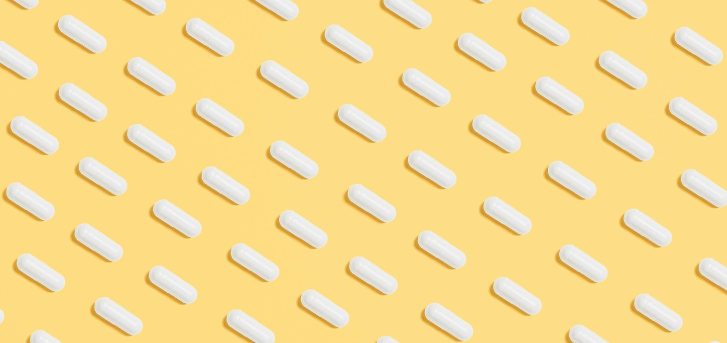 graphic image of white pills against a yellow background