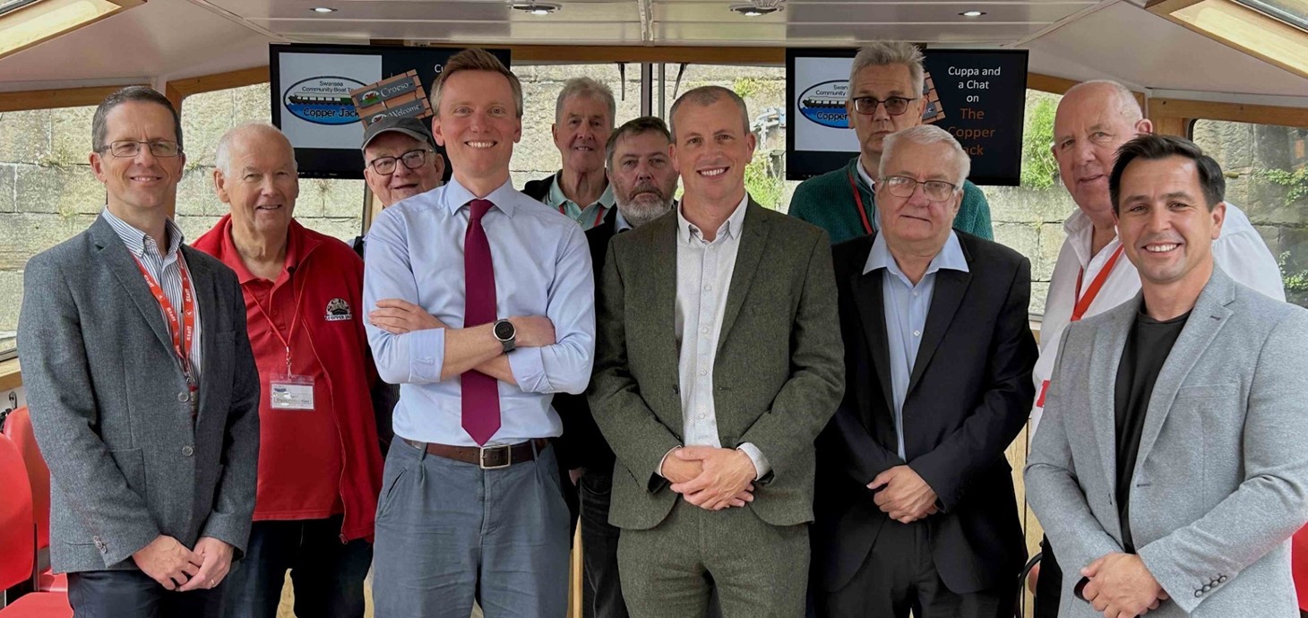 Group of 11 men standing inside a boat
