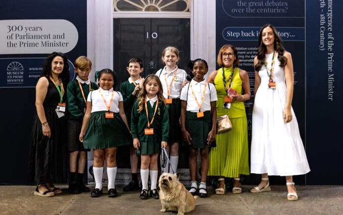 Achilles, accompanied by his guardian, Mrs Anne Allen, also Co-Headteacher of Danson Primary School, surrounded by smiling teachers and pupils from the school.