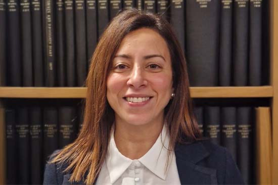 Head and shoulders of a woman in front of a bookcase