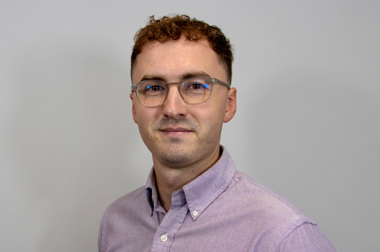 Man wearing shirt standing in front of plain background