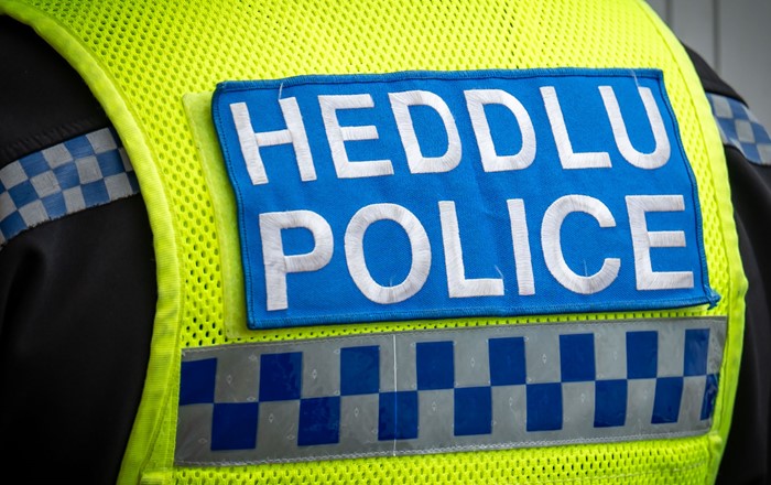 Bilingual police badge on back of high-vis jacket