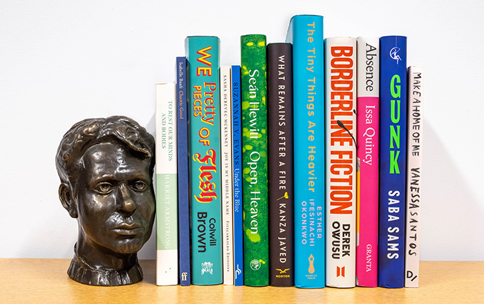 The books featured on the longlist on a shelf next to a small bust of Dylan Thomas