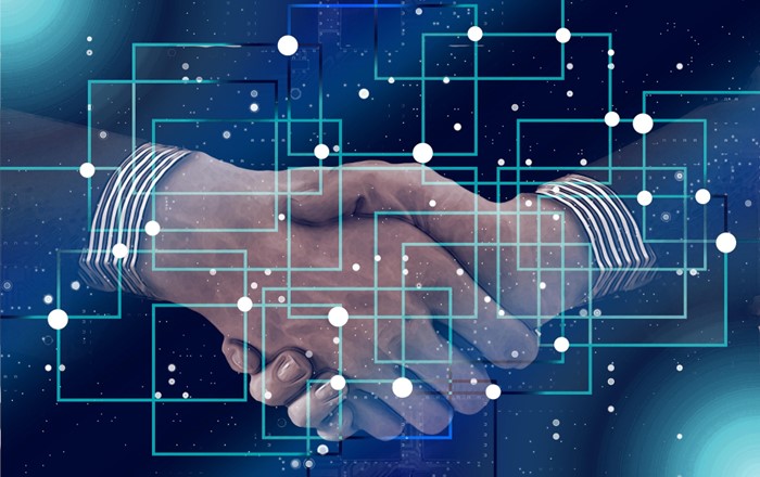 An image of handshake with an abstract image overlayed to depict a network