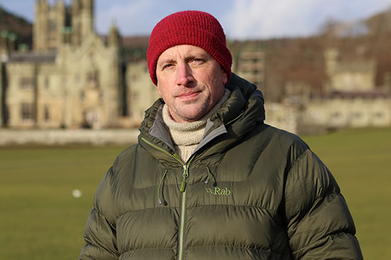 Man wearing cold weather clothing standing in front of castle