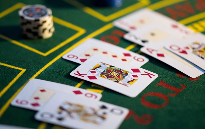 A close-up of a poker table with playing cards and chips