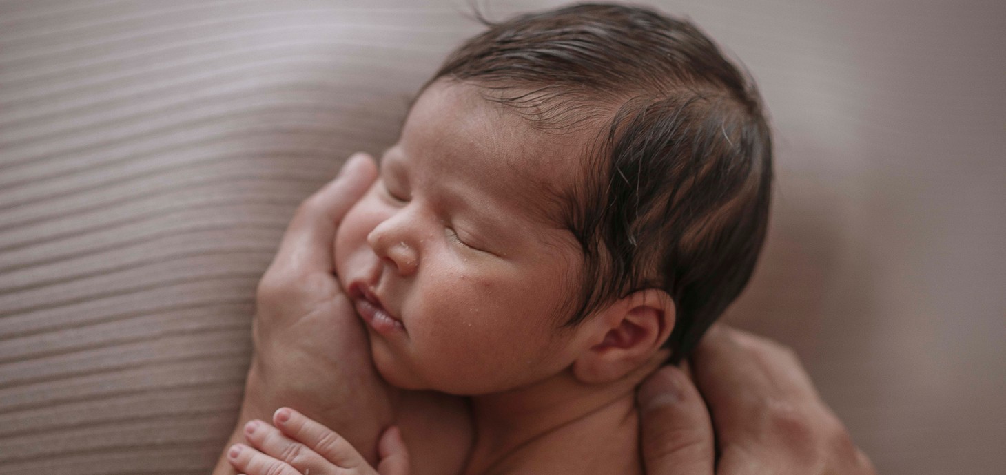 Baby sleeping in the hands of an adult