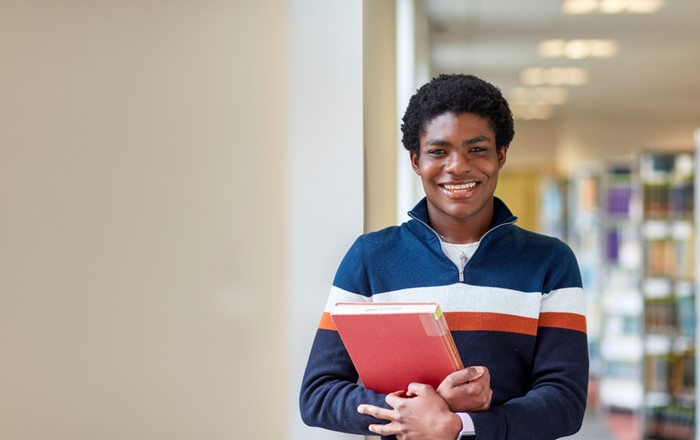 A student holding a book in the library 