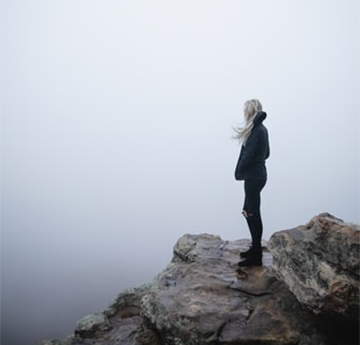 Woman in mist on rocks