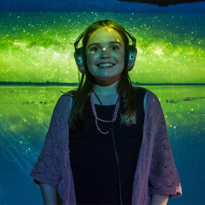 An image of a girl with headphones on. 